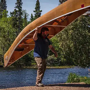 man portaging kevlar canoe bwca poplar lake rockwood