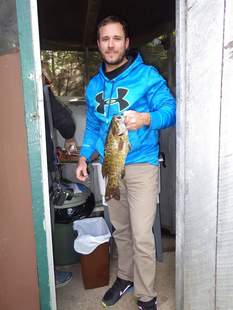 man holding fish in fish cleaning shack