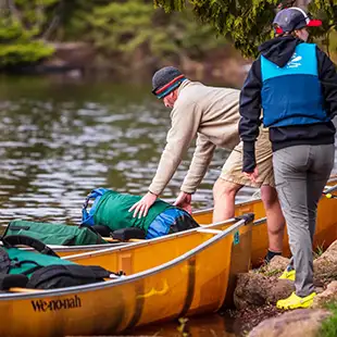 woman and man loading kevlar canoe bwca poplar lake rockwood